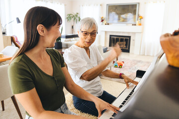 Mother And Daughter Learning Piano At Home © Lisa Weatherbee
