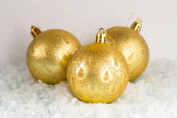 Three Golden Christmas balls on the snow