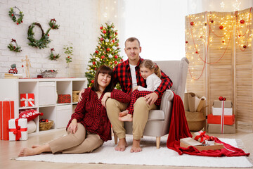Young beautiful family sitting in christmas decorated room