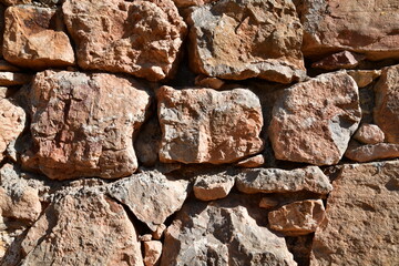 Background, texture of stone. An old wall of large rough stones.