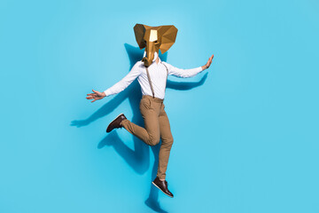 Full length photo of young guy jump carefree surreal incognito event isolated over blue color...