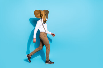 Photo of funky cool guy dressed wild animal mask walking empty space isolated blue color background