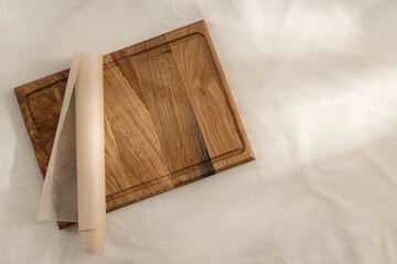 Top view of wooden cutting board,baking paper on the empty tablecloth.Free space