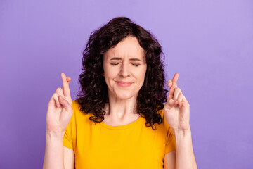 Photo of young attractive woman crossed fingers beg wish luck success isolated over violet color...