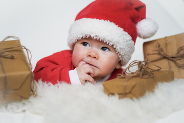 happy newborn baby in santa claus outfit with eco friendly natural paper gift box for christmas...