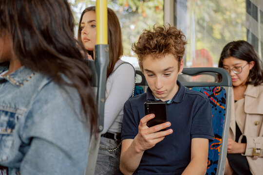 Crowd Of People On Bus Squeeze Afternoon In City Traffic Jams Young Women Sitting In Public Transport Coming Back From College Work Boy Coming Back From School Holding Phone In Hand Watching Videos