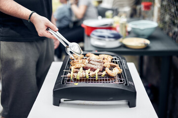 Preparing barbeque on a electrical modern grill outdoors.
