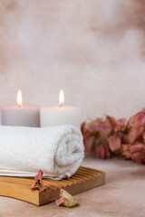 Spa still life treatment composition on massage table in wellness center. Twisted hot towel with...