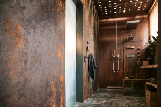 Modern bathroom with corten steel wall cladding and ceiling light effects