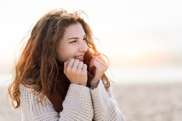 Young woman with redhead wearing scarf at beach