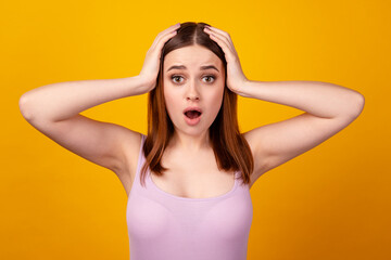 Fototapeta premium Photo of young impressed woman arms touch head shock surprised isolated over yellow color background