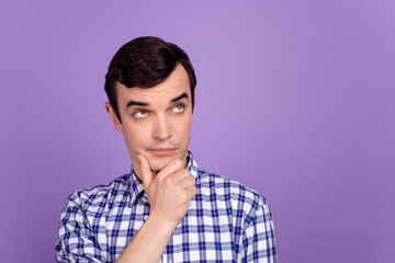 Photo of young man hand touch chin wondered look empty space thoughtful isolated over violet color background