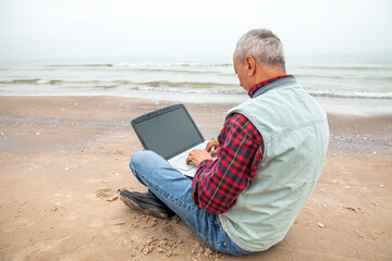 Old man with notebook on beach