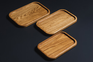 Wooden stylish cutting boards for the kitchen on a black background.