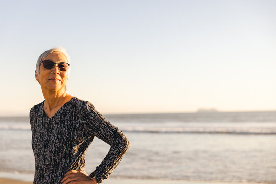 Smiling Retired Senior Woman At Beach During Sunset