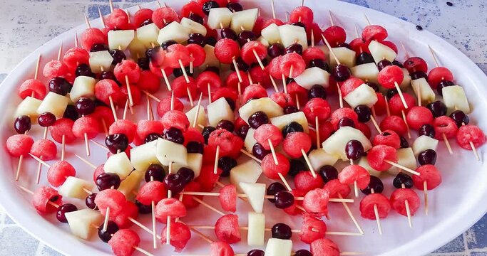 Fruit and berry skewers concept - simple healthy raw meal and ingredients - good for kids party - fresh summer fruit snacks - party healthy snack - Fresh fruit on sticks on plate