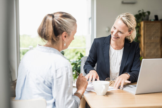 Businesswoman explaining customer while sitting at office