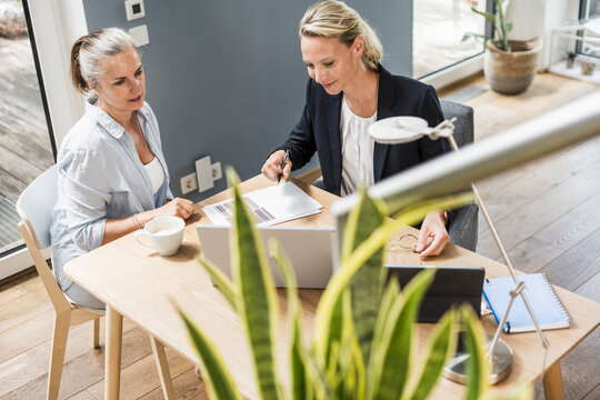 Female professional doing paperwork with customer at office