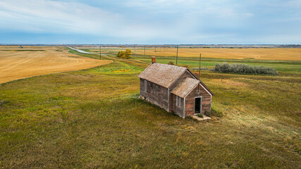 An old abandoned one room school house on the prairie of North Dakota in the evening.