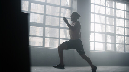 Fototapeta na wymiar Athlete standing on start position in crossfit gym. Man running in loft building