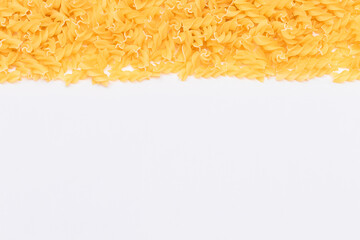 Uncooked Fusilli Pasta with Copy Space on White Background. Raw and Dry Macaroni. Fat and Unhealthy Food - Flat Lay