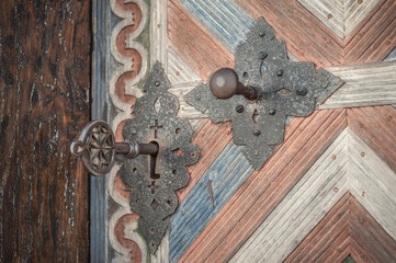 Closeup of old massive metal key in church ancient door