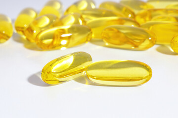 Fish oil capsules scattered on a white table