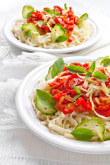 Pasta with tomato sauce basil and grated parmesan on the white plate