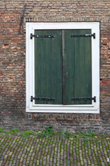 Closed antique green shutters on the window