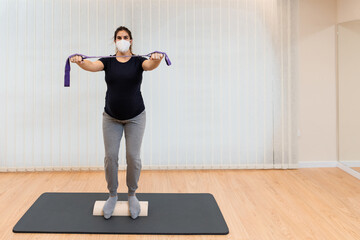 Fototapeta premium pregnant woman on a proprioceptive trunk for rehabilitation of lumboabdominal and perineal walls with , physiotherapist,