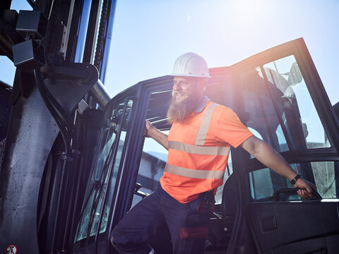 Austria, Tyrol, Brixlegg, Construction worker wearing reflecting clothing and hardhat standing by vehicle