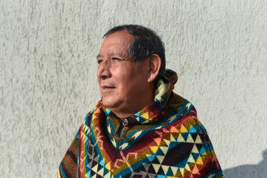 Thoughtful man wearing traditional poncho on sunny day