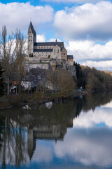 Fototapeta premium Reflection of the Basilica of Dietkirchen / Germany in the Lahn on a sunny spring day 