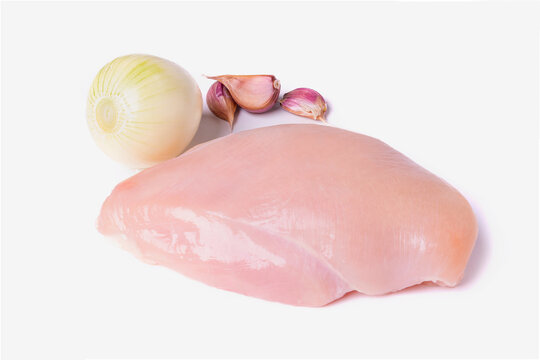Chilled chicken fillet isolated on a white background. Garlic head and onion next