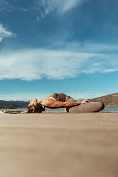Sportswoman doing Matsyasana on jetty
