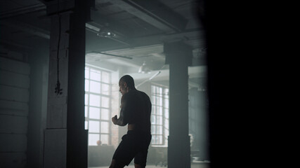 Fototapeta na wymiar Fighter practicing kicks during training. Man practicing boxing in sports club