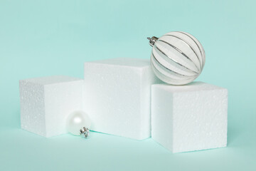 Simply minimal composition winter objects ornament and cube shapes geometric form podium isolated blue pastel background. Christmas New Year december time for celebration concept. Mockup copy space