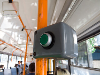 Stop button in city tram. Button open door request in public transport. Close up