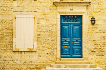 Stone house with blue door and shutters window