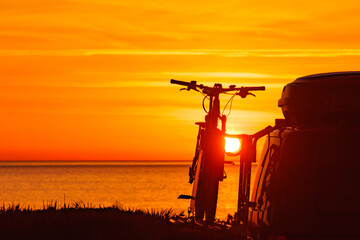 Naklejka premium Camper with bicycles on rack camping on beach at sunrise