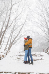 Fototapeta na wymiar Couple hugging and kissing in the snow