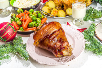Festive Christmas dinner table with traditional foods and dished – baked ham, chicken, roasted carrots and brussels sprouts, potato, with Christmas decor and gifts 