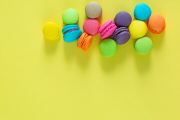 Sweet and colorful french macaroons or macaroon on yellow background, Dessert eating with tea or coffee.