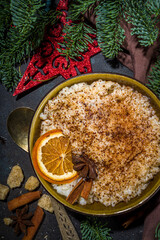 Risgrynsgrot, scandinavian-style Christmas rice porridge with cinnamon and spices, with Christmas tree branches decor 