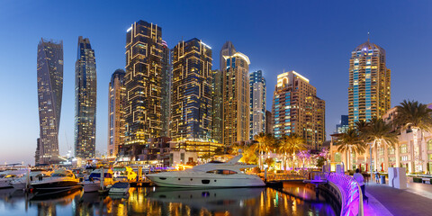 Dubai Marina and Harbour skyline architecture wealth luxury travel with yacht boat at night...