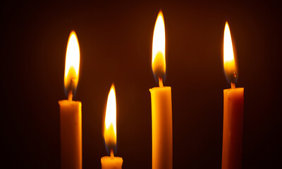 Many burning candles on black background