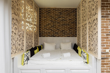 sleeping place with double bed and faux brick wall decoration carved screens zoning space with a pattern of flowers