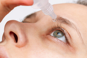 Cropped shot of woman dripping her eye with medicinal drops natural tear.Disease of retina of...
