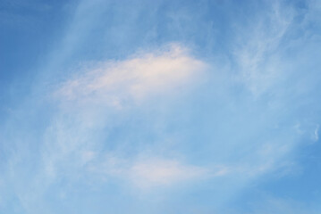 Moving cloud illuminated by  evening light in blue sky atmosphere. Abstract nature blurred background.