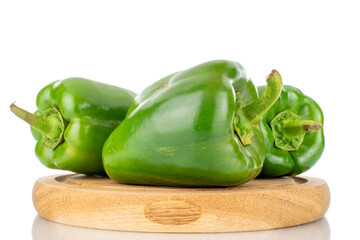 Four sweet green peppers on a wooden tray, close-up, isolated on white.